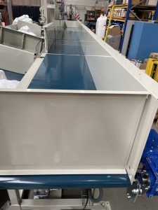 Máquina automatizada transportando nórdicos entre estaciones de costura